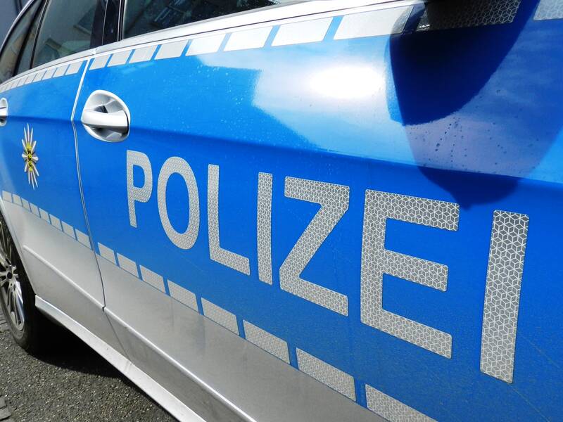 Ein blau-weißes Polizeiauto mit der Aufschrift "POLIZEI" an der Seite.
