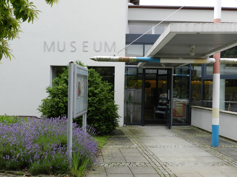 Außenansicht des Eingangs des Museums, mit Lavendel und Infotafel im Vordergrund