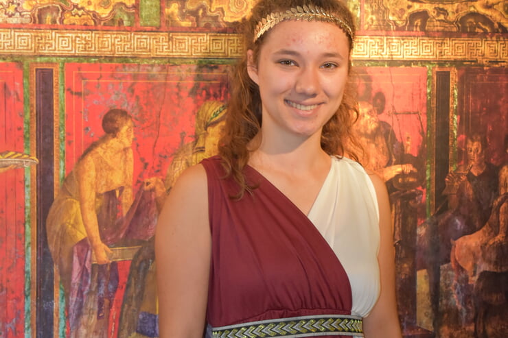 Ein Mädchen das als Römerin verkleidet ist, trägt eine rot weiße Tunika