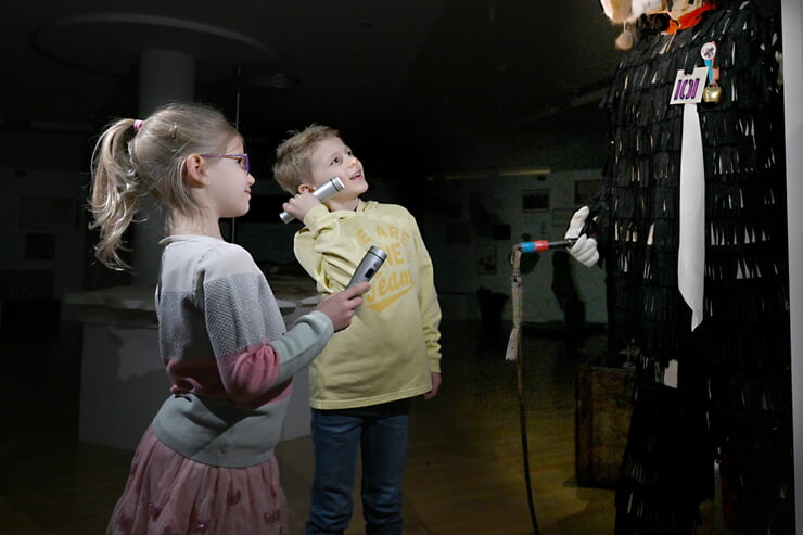 Kinder laufen mit Taschenlampen durchs Museum