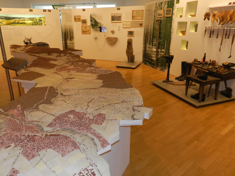 Innenansicht des Stadtmuseums, links eine große Gebietsansicht, rechs und im Hintergrund diverse Ausstellungsobjekte