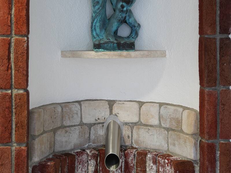Das Bild zeigt einen Eisbrunnen, darüber ist eine Statue angebracht.