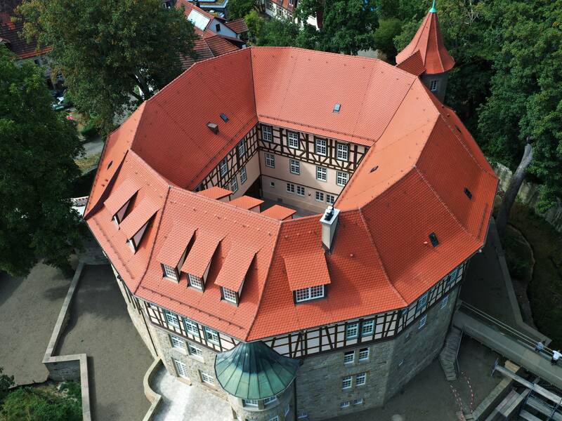Blick von oben auf den runden Bau des Wasserschlosses