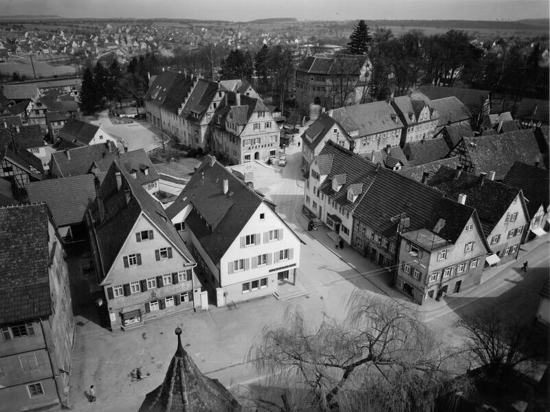 Eine malerische, historische Stadtansicht mit Fachwerkhäusern in einer verschlungenen Anordnung von Straßen.