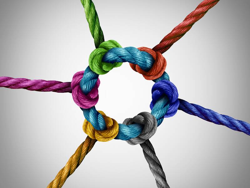 Ein zentraler Knoten verbindet mehrere bunte Seile, die in verschiedene Richtungen verlaufen.