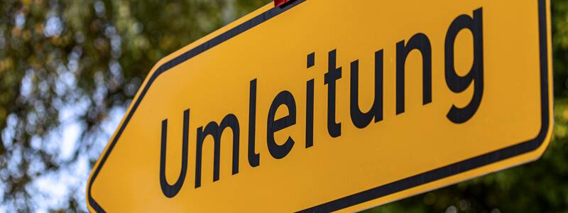 Ein gelbes Umleitungsschild, das in die linke Richtung zeigt.